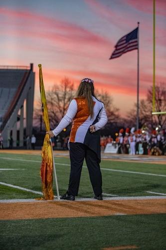 一个学生 holding flag during sunset